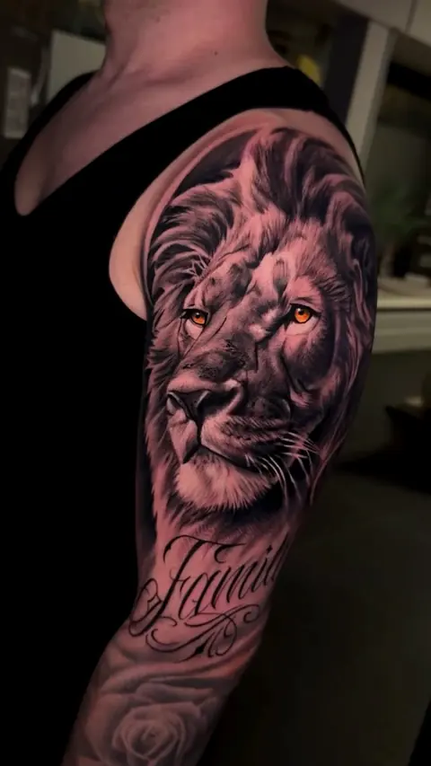 Leão realista no ombro com lettering